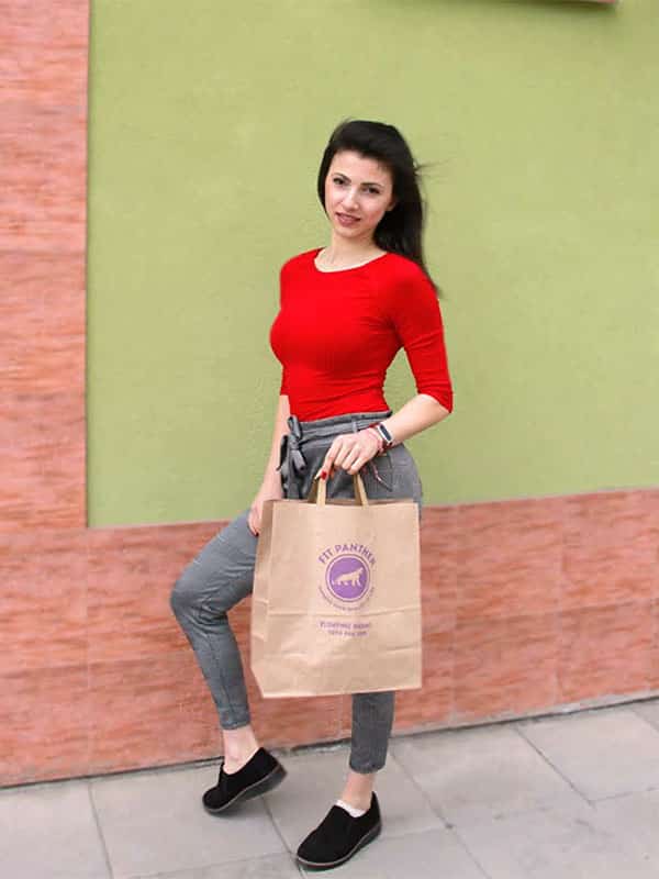 young woman with a package with healthy food from Fit Panther